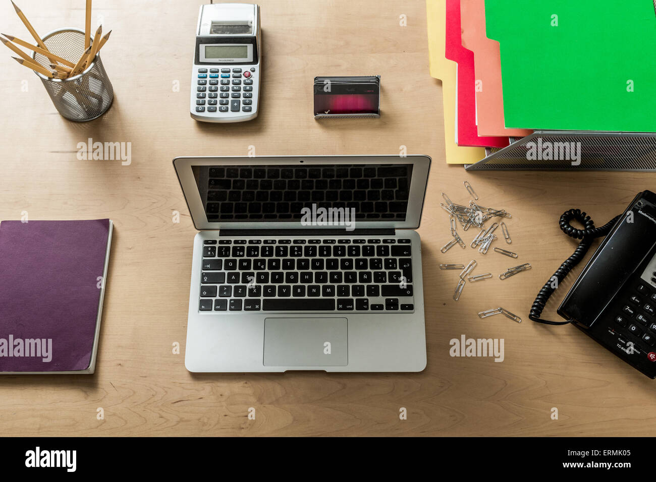 Un moderno espacio de trabajo en su oficina doméstica con laptop, calculadora, teléfono, lápices y otros objetos desde arriba Foto de stock