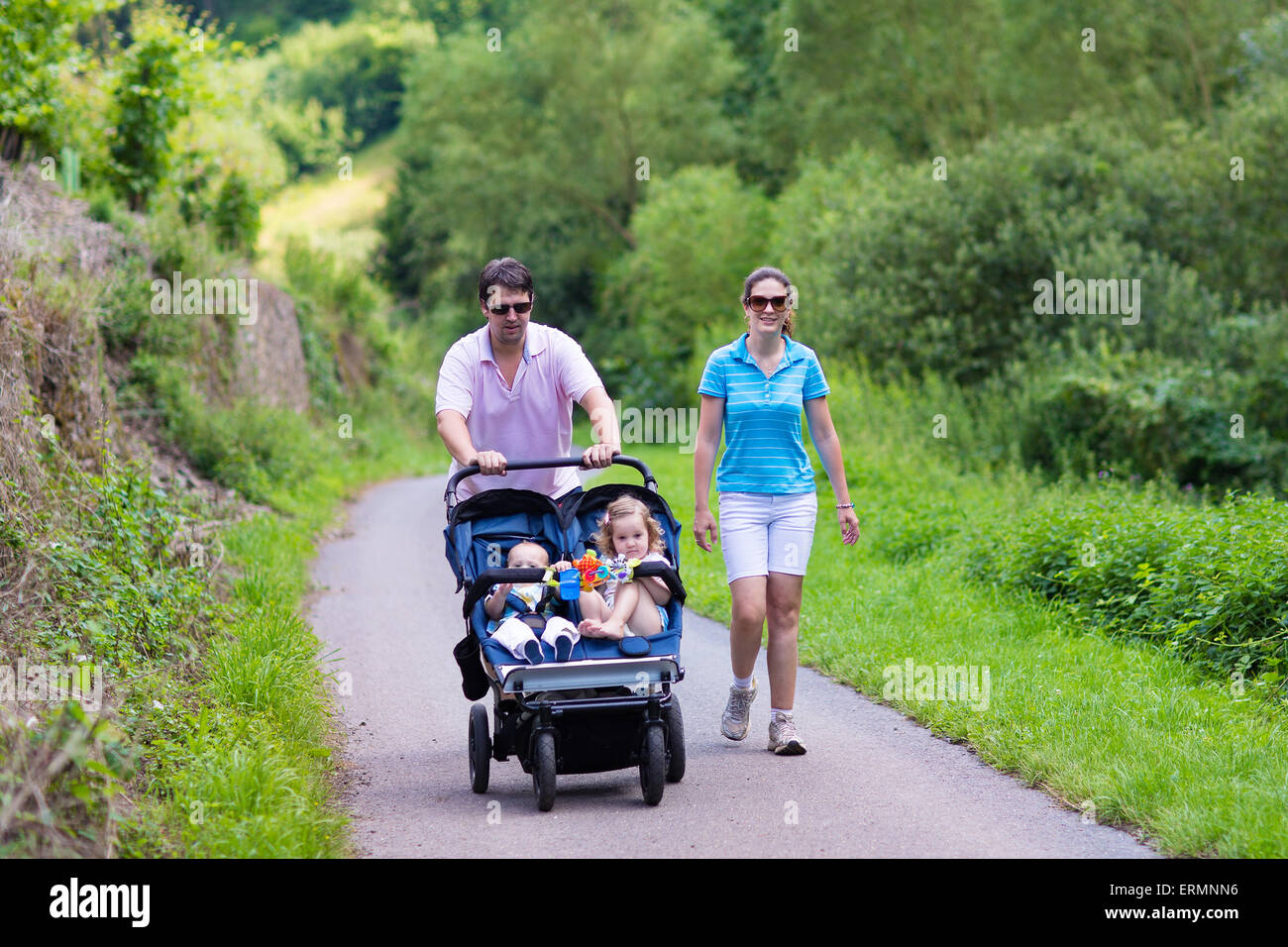 Los padres jóvenes, el senderismo en las montañas con doble twin silla de  paseo con dos niños, hermano y hermana, Baby Boy y Girl toddler Fotografía  de stock - Alamy