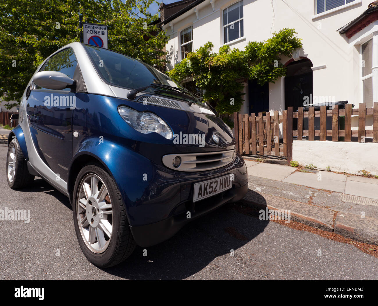 Gran angular, de bajo nivel, la vista de un coche Smart aparcados en la acera, fuera de una casa en la calle Ellerdale, Lewisham. Foto de stock