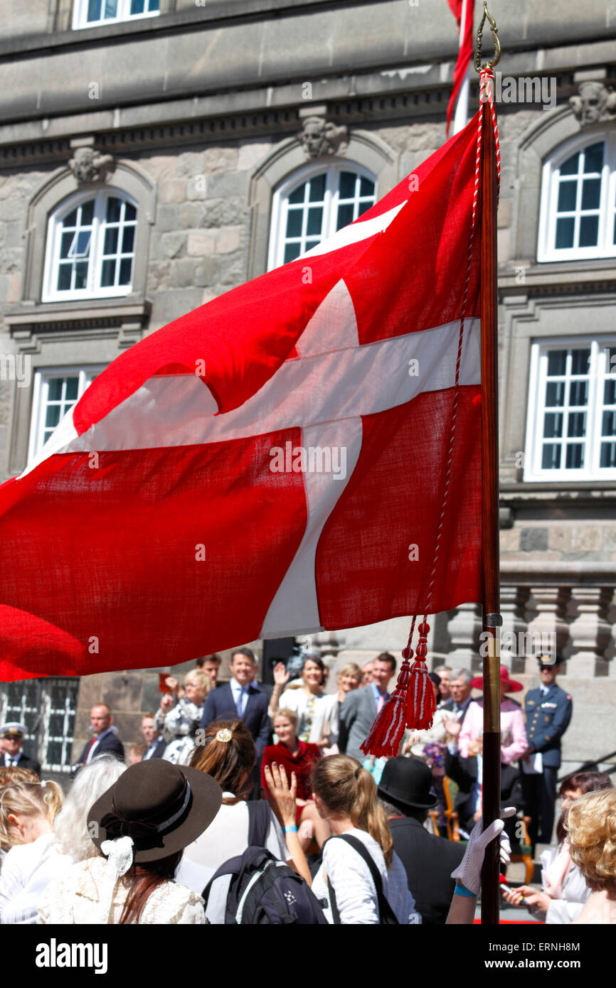 Copenhague, Dinamarca, el 5 de junio, 2015. La familia real y los representantes del Gobierno y del Parlamento en el patio del palacio de Christiansborg visto bajo la bandera danesa en el acabado del desfile conmemorativo en el día de la Constitución con motivo de la celebración del 100º aniversario de la Constitución las modificaciones en 1915, dando a la mujer el derecho a votar y a presentarse a las elecciones. Saludo mutuo y vítores. Muchos de los participantes en la marcha están vestidos en el histórico 1915 prendas de vestir. Crédito: Niels Quist/Alamy Live News Foto de stock