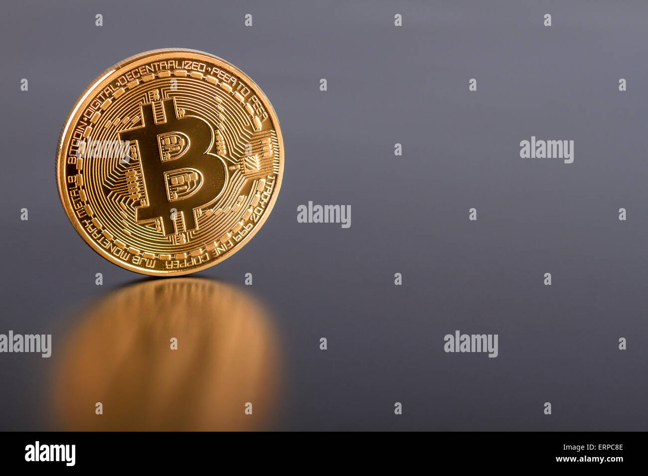 Foto de estudio de la moneda virtual Bitcoin dorados sobre fondo gris. Cerca de la parte frontal. Foto de stock