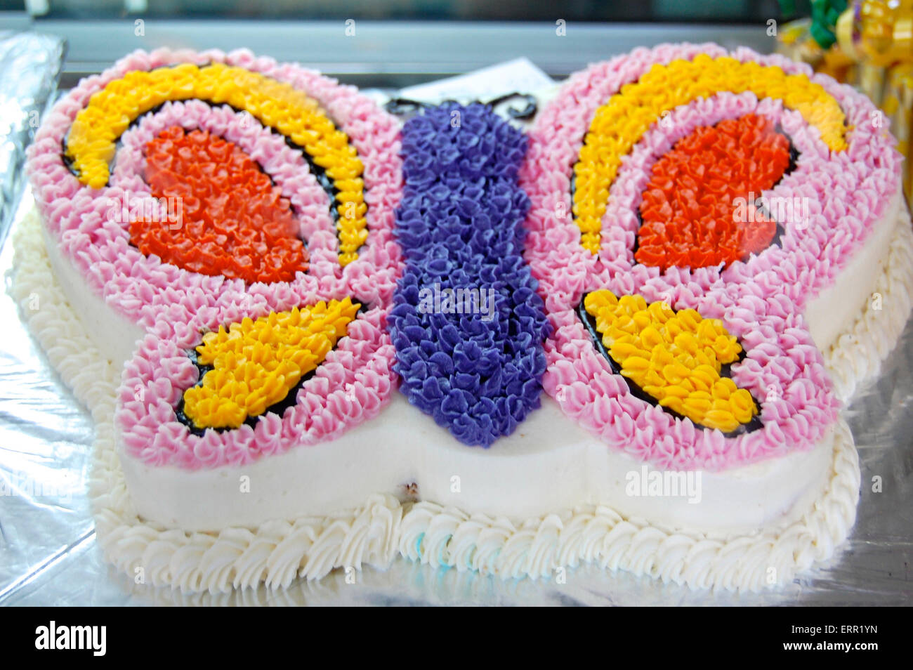 Un pastel en la forma de una mariposa cubiertos en rosa brillante amarillo  morado rojo guinda Fotografía de stock - Alamy