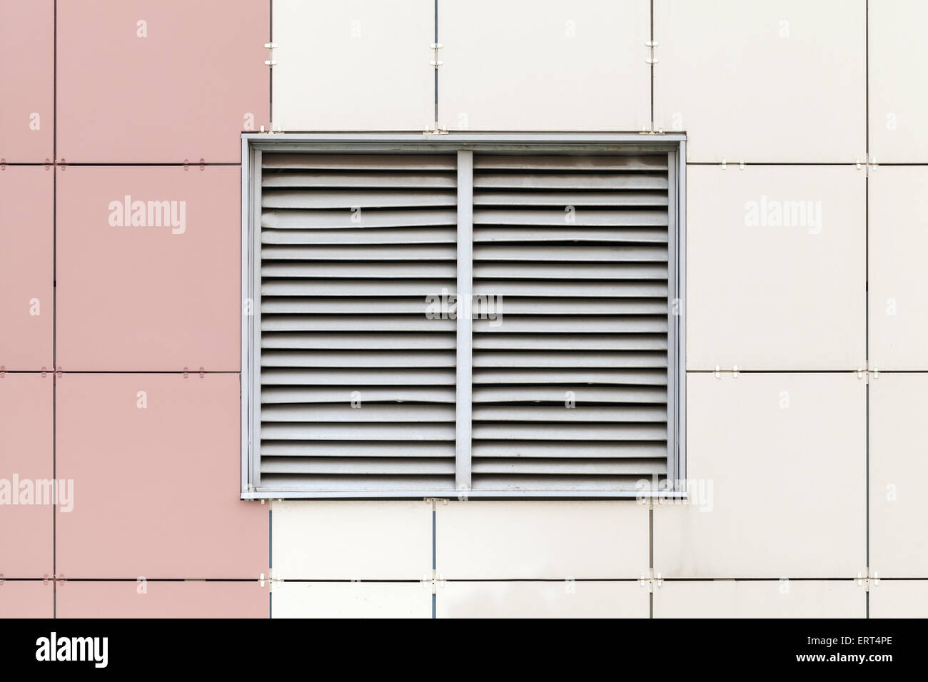 Rejilla de ventilación gris en la ventana, fachada de edificio industrial moderno fragmento Foto de stock