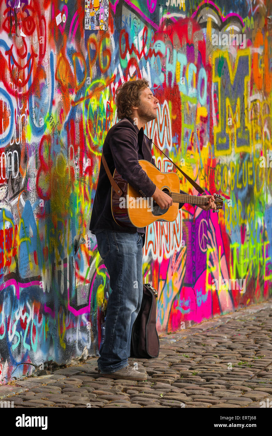 Praga, República Checa - Mayo 21, 2015: Praga Calle músico músico callejero realizando Beatles canciones delante del famoso John Lennon Wal Foto de stock