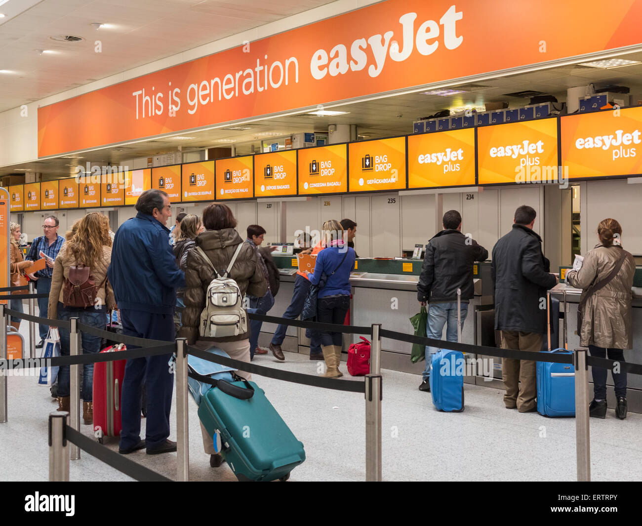 La compañía aérea Easy Jet check-in en el aeropuerto de Gatwick, Londres, Inglaterra, Reino Unido - con una línea de personas en cola Foto de stock