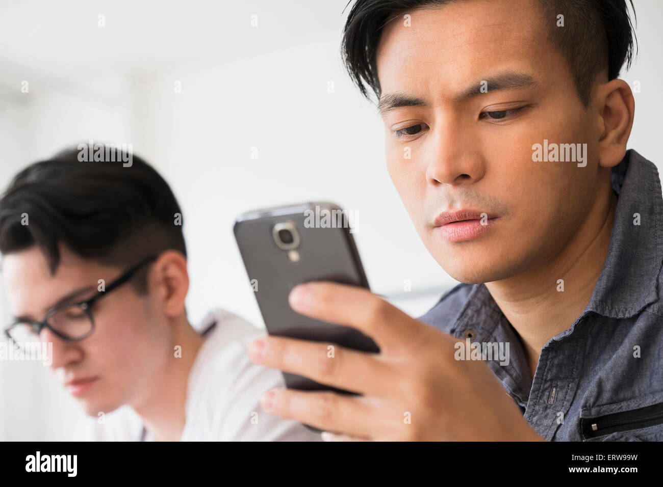 Primer plano de un hombre serio texting en teléfono celular Foto de stock