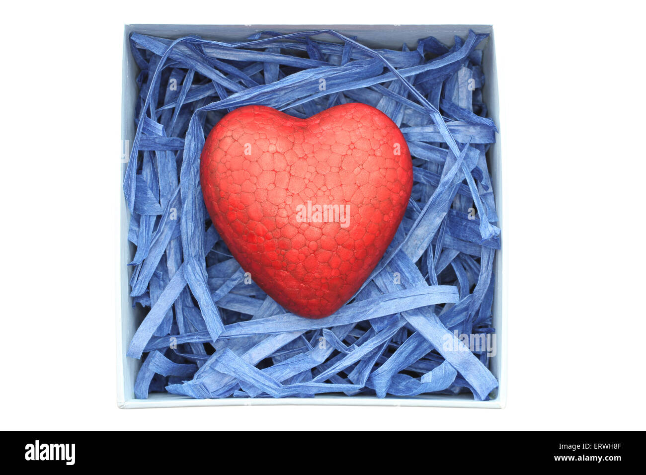 Poliespuma pintadas de rojo corazón cerrado con tiras de rafia papel azul en el cuadro azul claro aislado sobre fondo blanco. Foto de stock