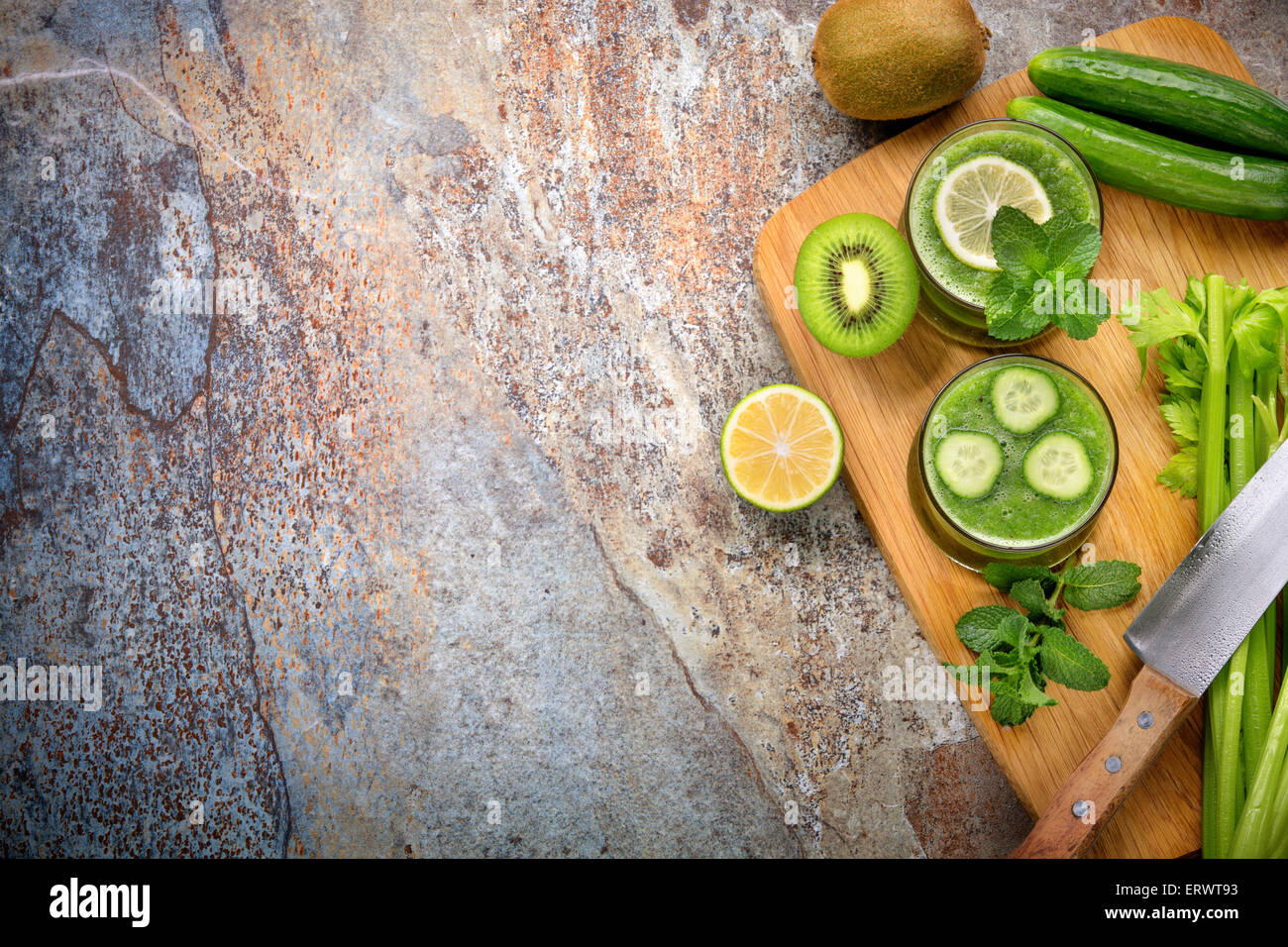 Smoothie verde,pepino, limón, kiwi y apio en el fondo de piedra Foto de stock