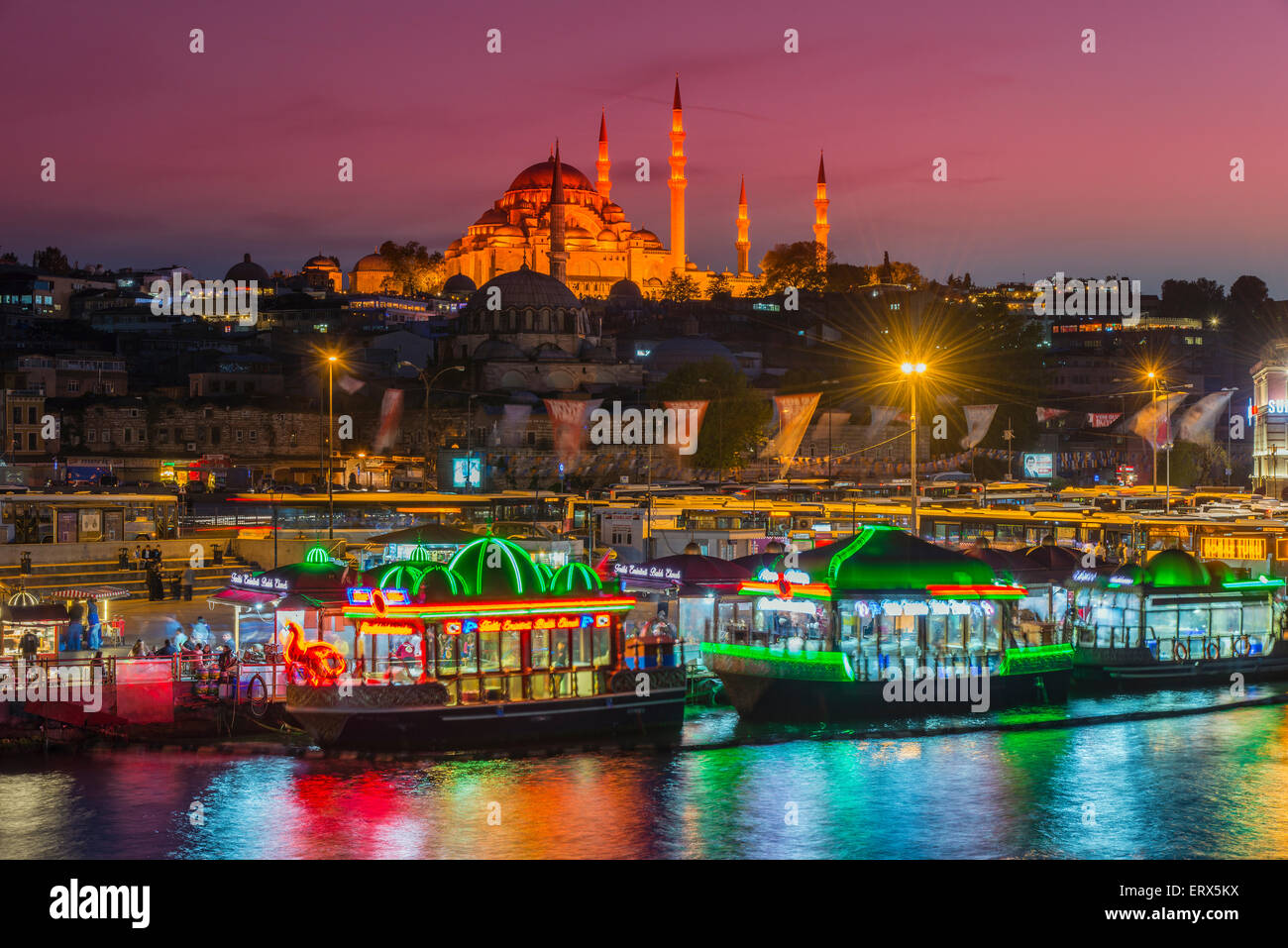 Restaurantes Barcos flotando sobre el Cuerno de Oro con la Mezquita Suleymaniye detrás al anochecer, Estambul, Turquía Foto de stock