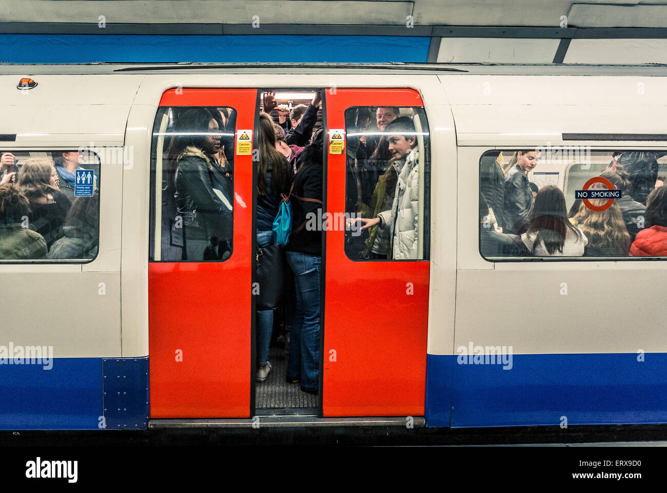 Tubo lleno de gente en el tren subterráneo de Londres - cierre puertas Foto de stock
