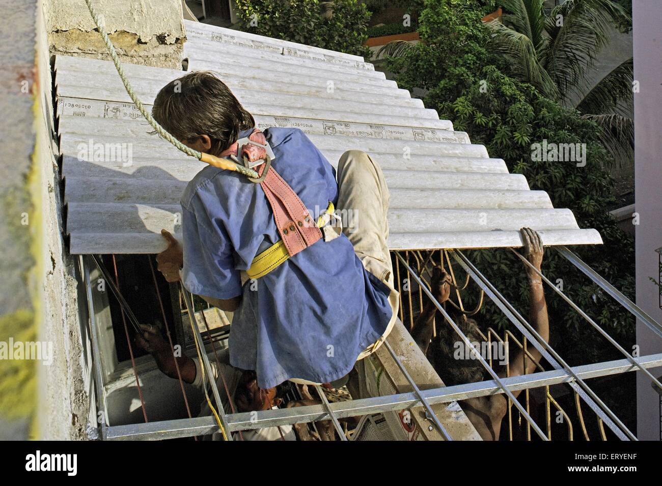 Hombre fijando la hoja de cemento de asbesto, india, asia Foto de stock