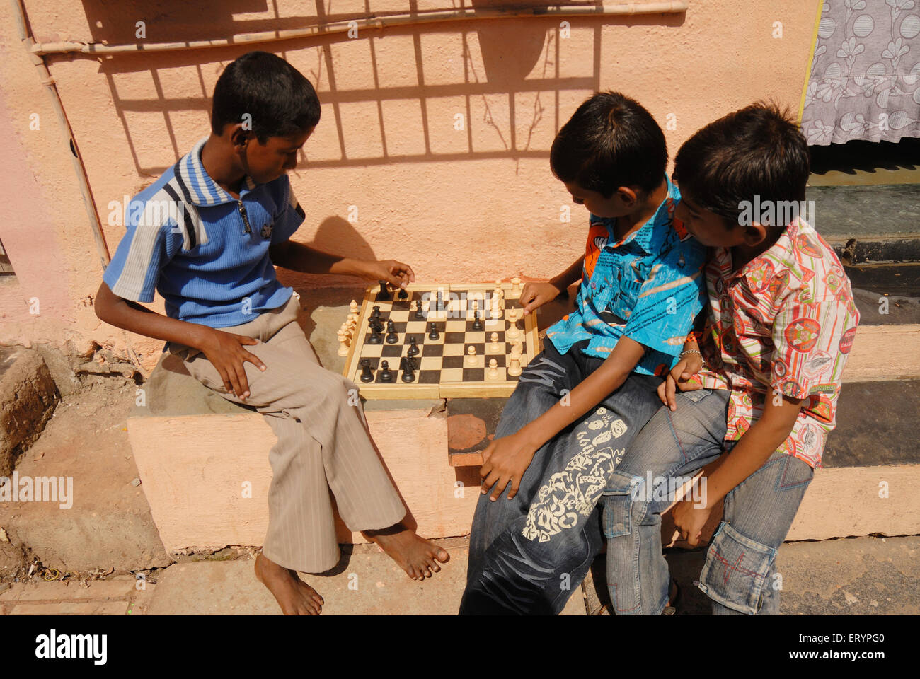 Los niños de la escuela el juego de ajedrez durante sus vacaciones fuera de sus hogares en Bombay, Maharashtra, India Mumbai ; ; Foto de stock