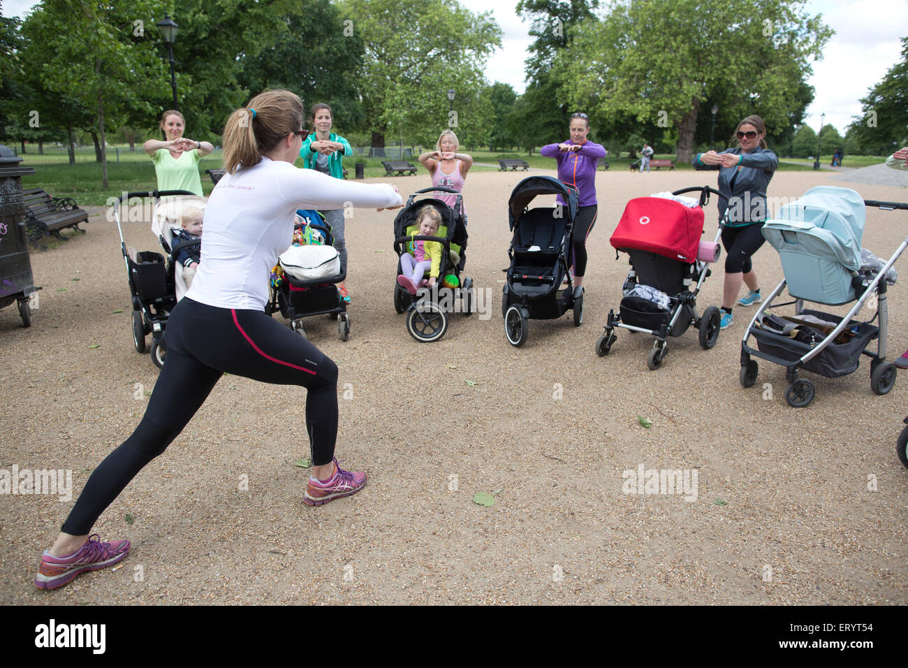 La madre de tomar una clase de ejercicios con el bebé y el niño en sus buggies en un parque de Londres, Inglaterra, Reino Unido. Foto de stock