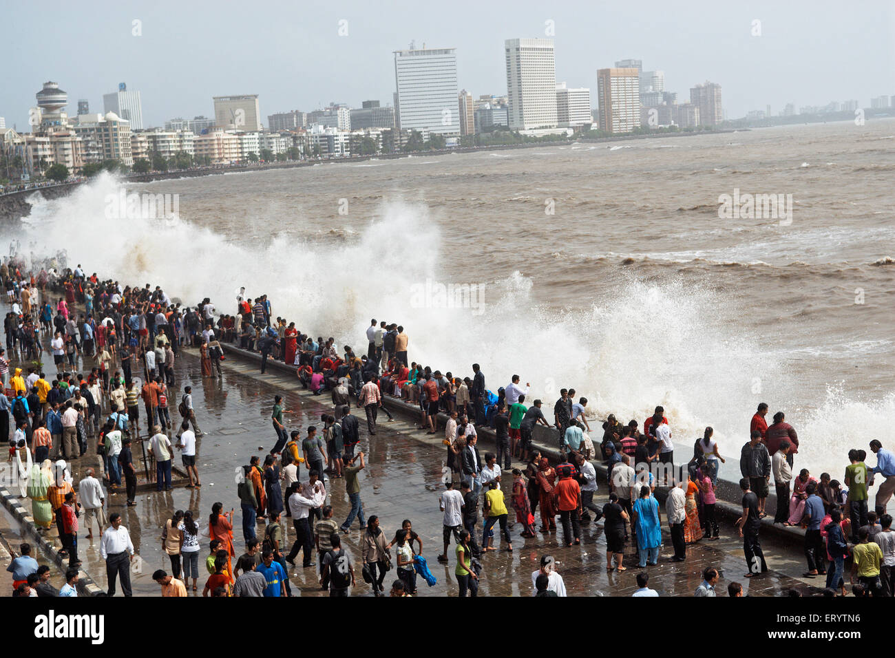 El monzón de Mumbai , gente que disfruta de las olas del mar , Marine Drive , Bombay , Mumbai , Maharashtra , India , Asia Foto de stock
