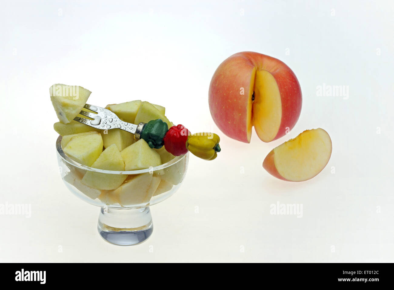 Apple América Malus pumila pedazos en un cuenco de fruta Fruta decorativa con horquilla y cortar una rodaja de manzana Foto de stock