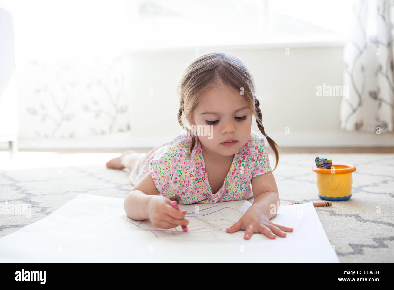 Chica en piso de dibujo con lápices de colores Foto de stock