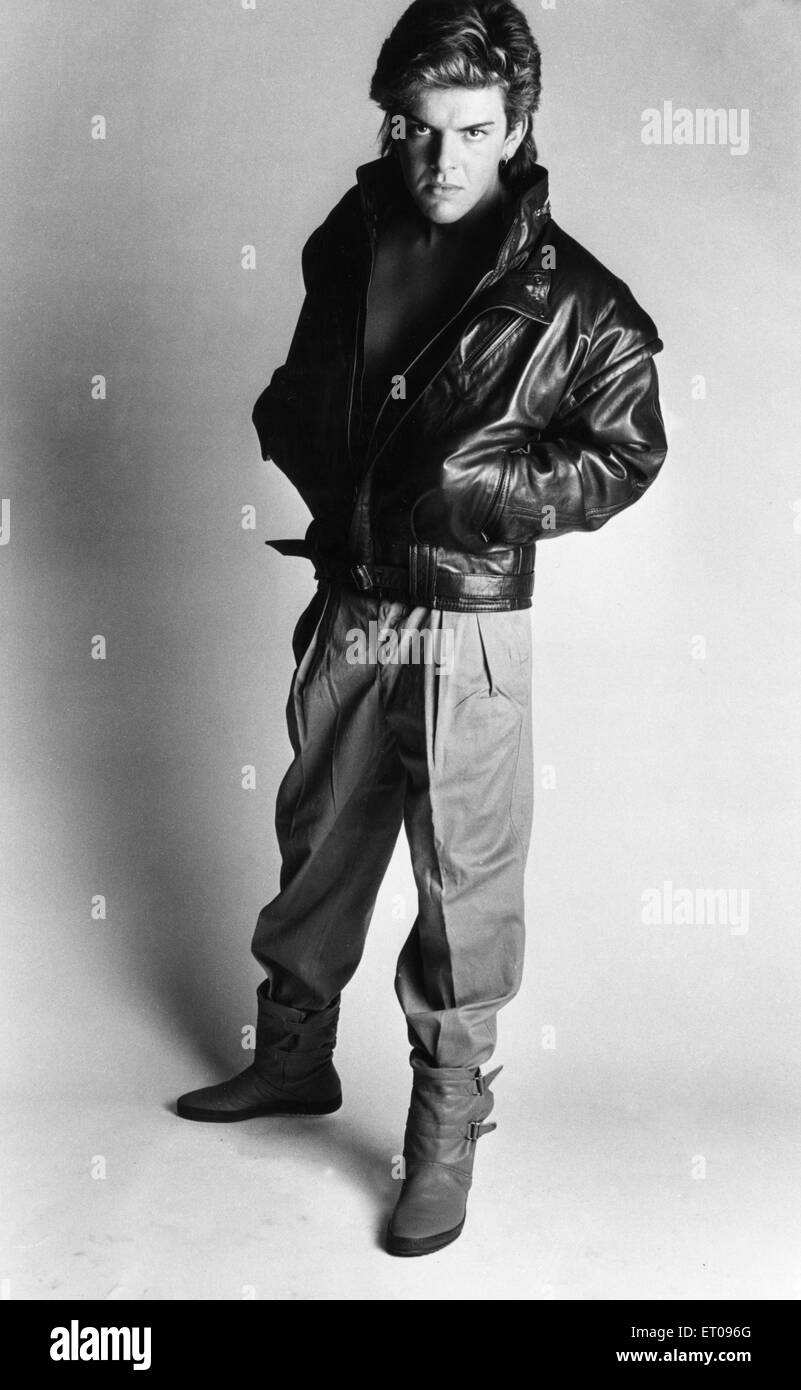 Mens moda Primavera 1985. Nuestro modelo lleva una chaqueta de cuero negro,  pantalón plisada metidos en botas de cuero. El 27 de marzo de 1985  Fotografía de stock - Alamy
