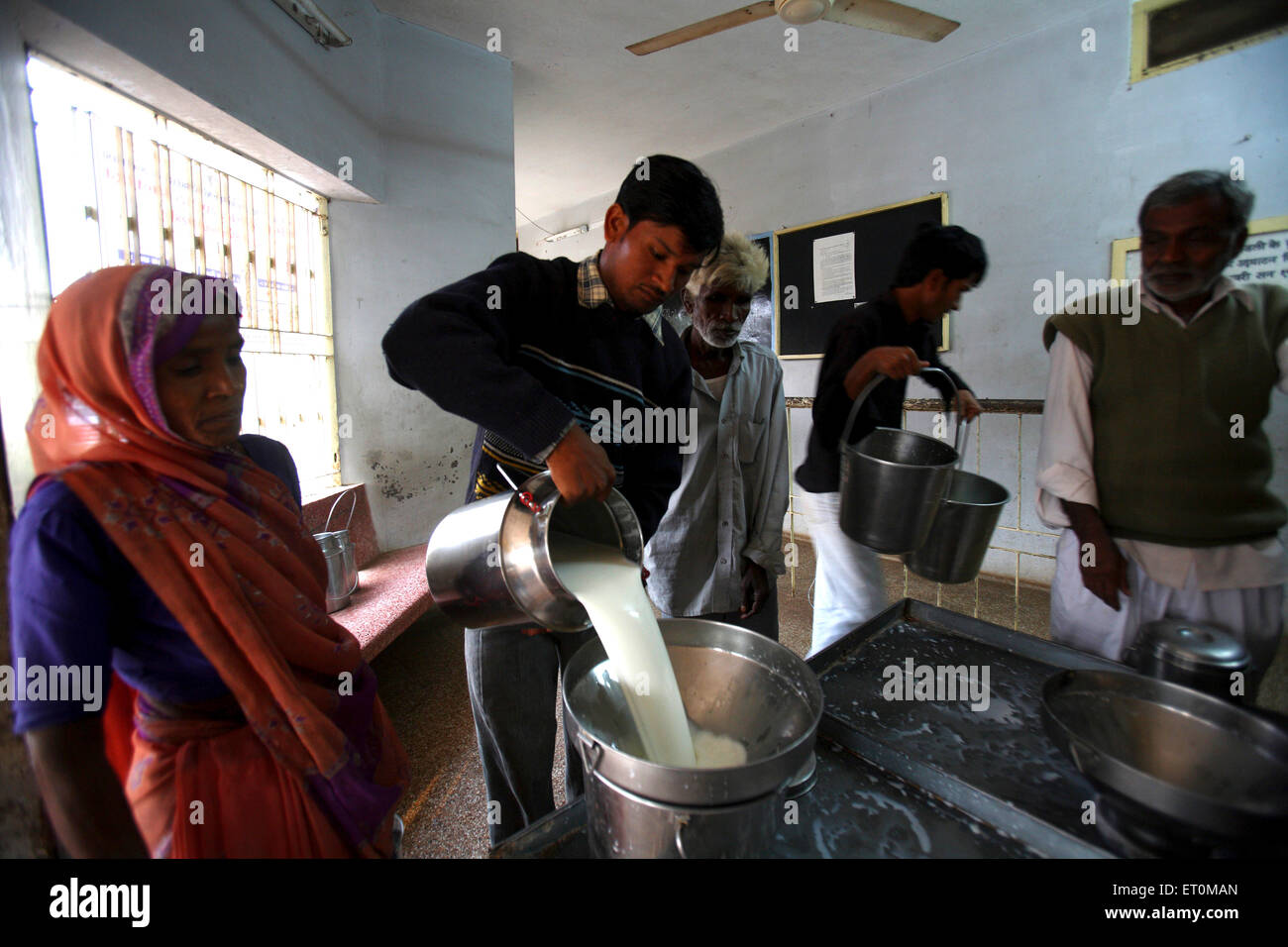 Los productores de leche de depositar sus días cuota de leche al centro de acopio de Gujarat Co operativa Milk Marketing Federation Foto de stock