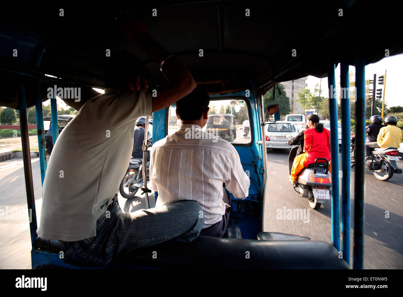 Pasajero sentado detrás del conductor en auto ricksha en el territorio de la Unión de Chandigarh, India Foto de stock