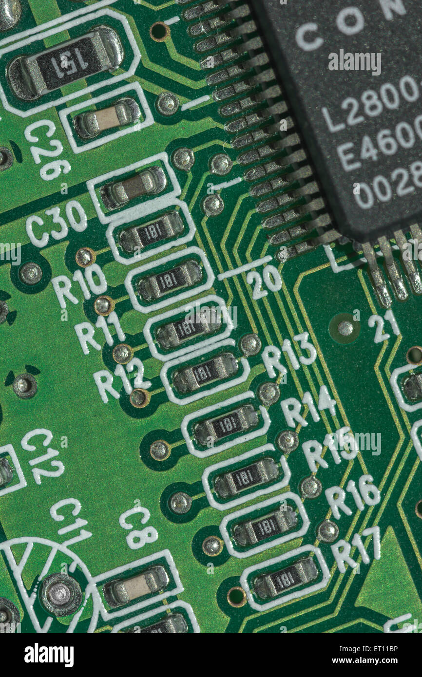 Macro-foto de componentes de circuitos impresos en una placa base de PC.  Cableado en el interior del ordenador, cierre del circuito, detalle de una  placa de circuitos, puntos conectados Fotografía de stock -