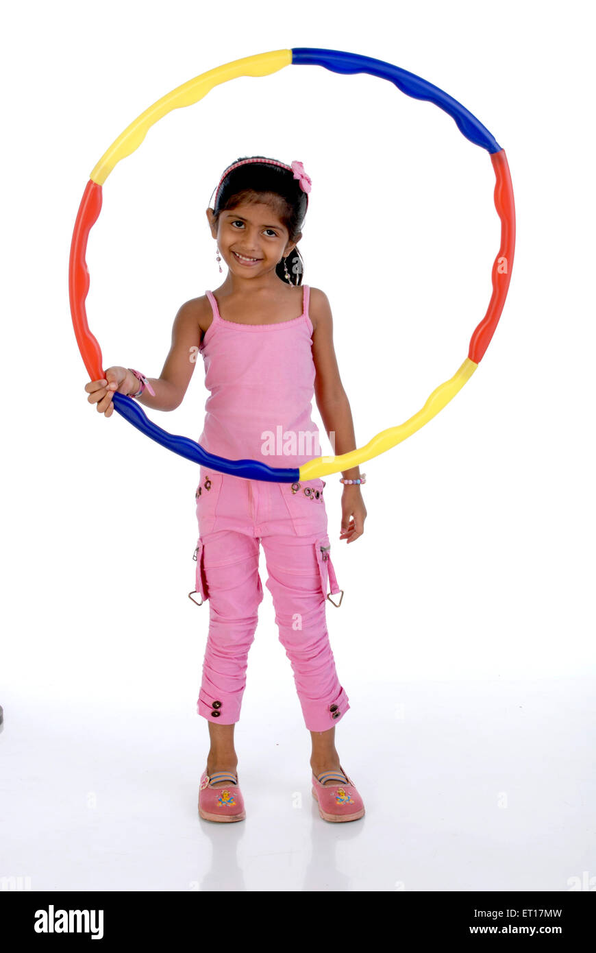 Una niña jugando hulahoop sobre fondo blanco.