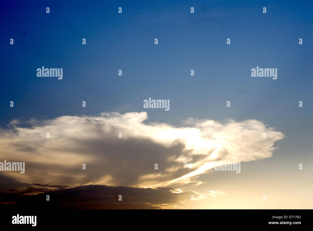 Cielo azul con nubes blancas con forro plateado durante la puesta de sol Foto de stock