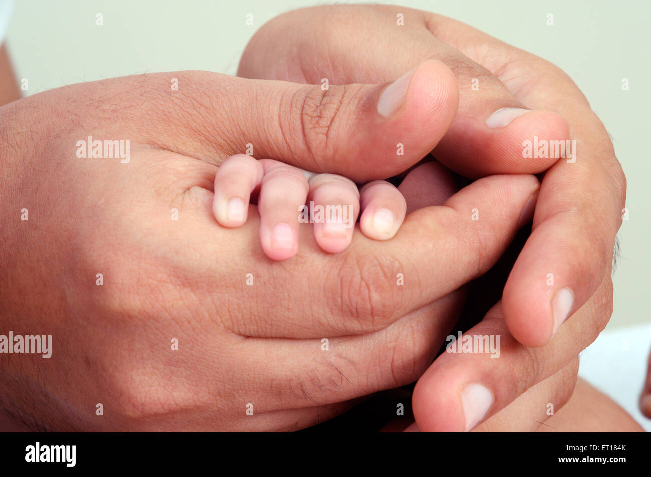 Padre sosteniendo la mano de new born baby - MR#736J y MR#736LA Foto de stock