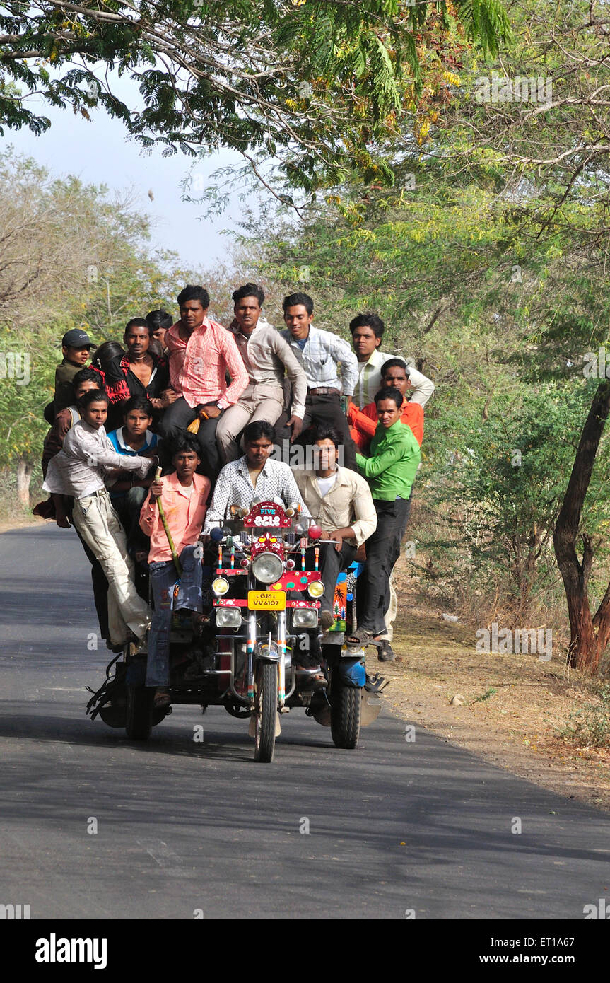 Diecisiete hombres sobrecargados congestionados en el triciclo de taxi rickshaw en el transporte en moto Chhota Udaipur Gujarat India Asia India Asiática Foto de stock