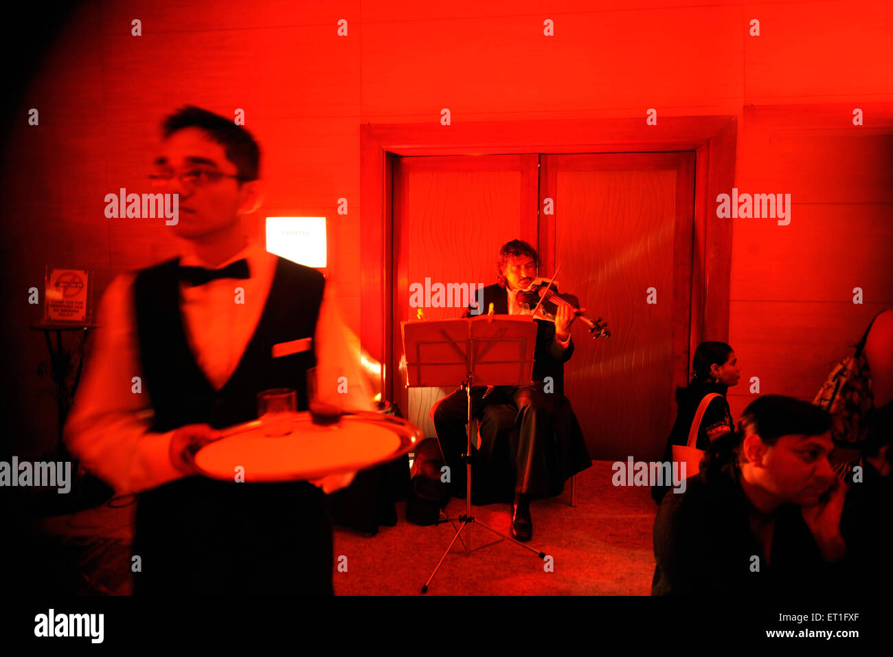 Música en vivo en el restaurante músico tocando instrumentos musicales violín Foto de stock