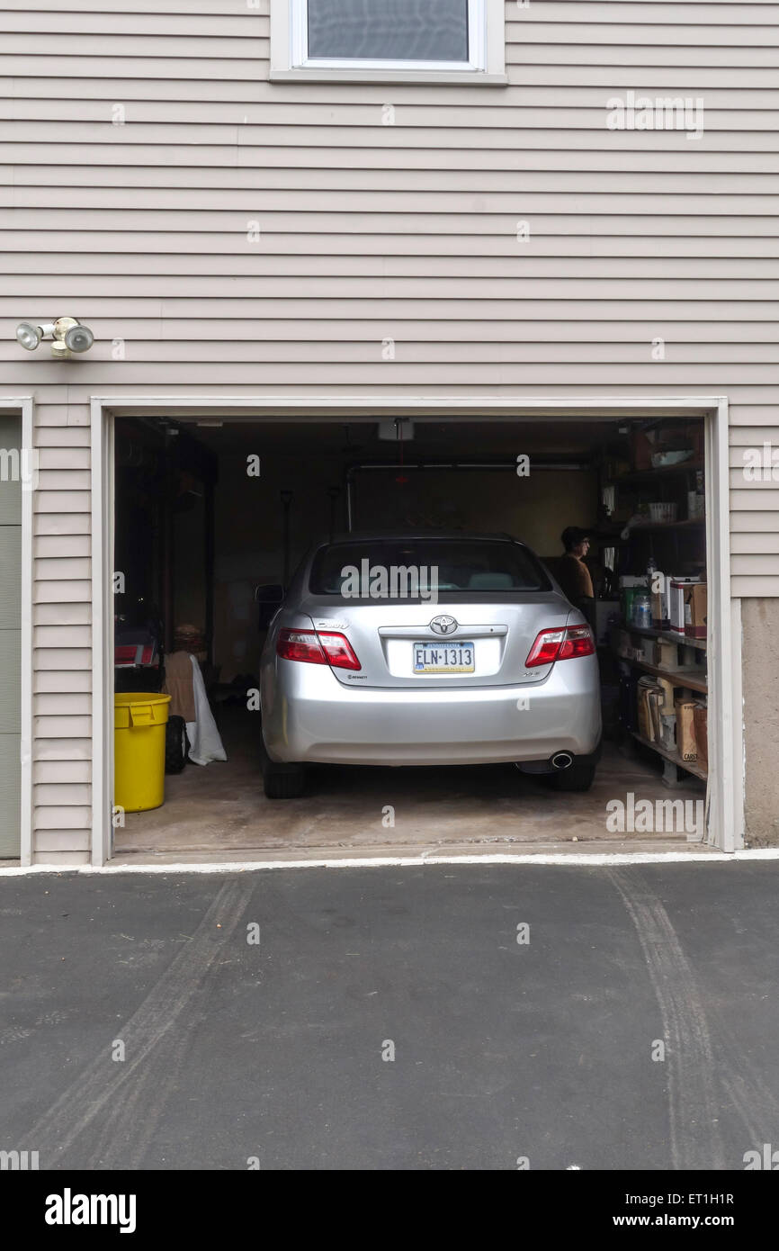 Abrir la puerta del garaje con el coche aparcado en el interior, la casa de madera de estilo americano, EE.UU.. Foto de stock