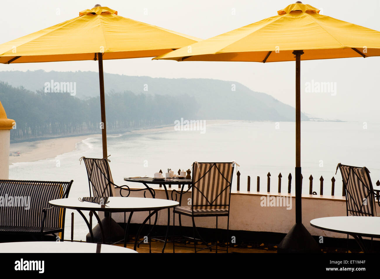 Paraguas amarillo y mar a fuertes terakhol Goa hotel ; ; India Foto de stock