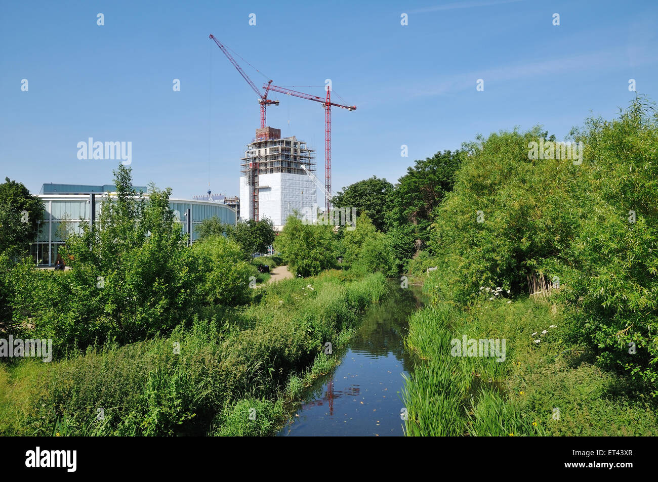 Río Ravensbourne, Lewisham, South East London, con bloque de apartamentos en construcción Foto de stock