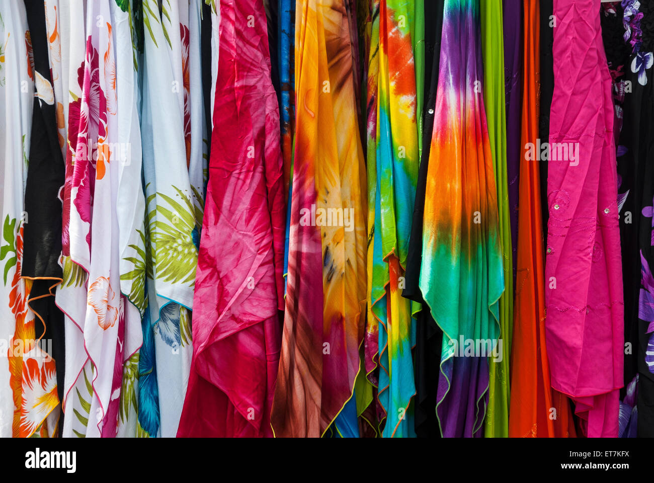 Colorida ropa de mujer para venta, colgados en perchas. Foto de stock