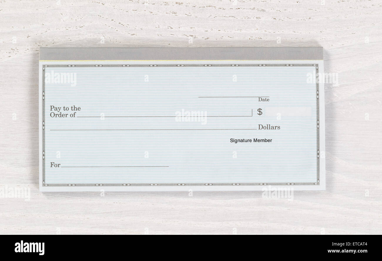 Cerca de cheque en blanco sobre blanco, escritorio de madera. Diseño en formato horizontal. Foto de stock