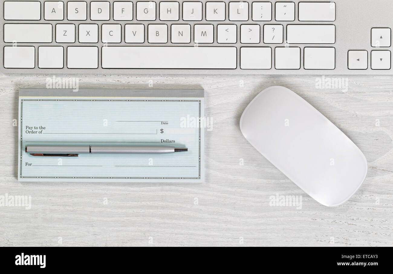 Imagen del teclado parcial, cheque en blanco, Pluma de Plata y el ratón de escritorio blanco. Diseño en formato horizontal. Foto de stock