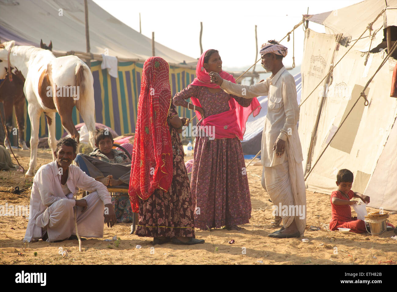 Familia Rajasthani relajarse y hablar. Feria de Pushkar, Rajastán, India Foto de stock