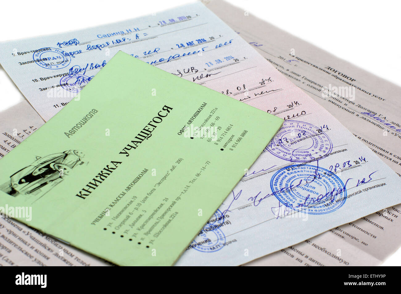 Gerente de servicio del vehículo llenado documentos celebración carpeta con  licencia de conducir en el showroom con el coche en el fondo Fotografía de  stock - Alamy