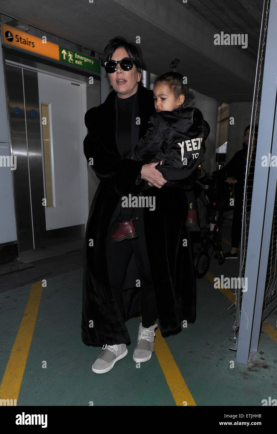 Kris Jenner, vistiendo un par de Kanye West Yeezy Adidas x 750 Boost, llega al aeropuerto de Heathrow llevando bebé North West, quien llevaba una chaqueta de bombardero Yeezus Tour' en