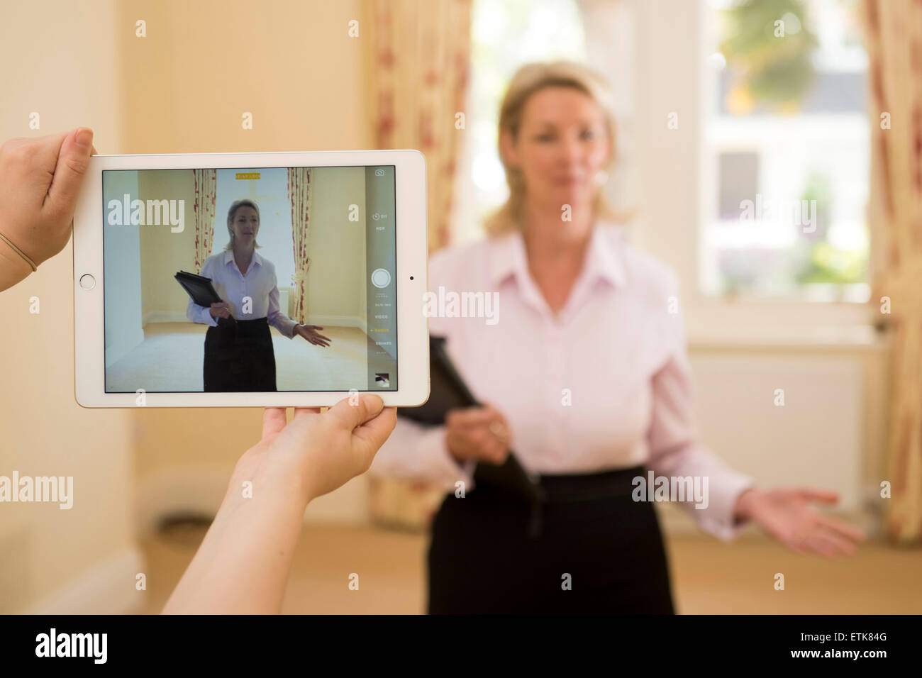 Un agente inmobiliario dando un tour virtual de una propiedad utilizando un IPAD. Foto de stock