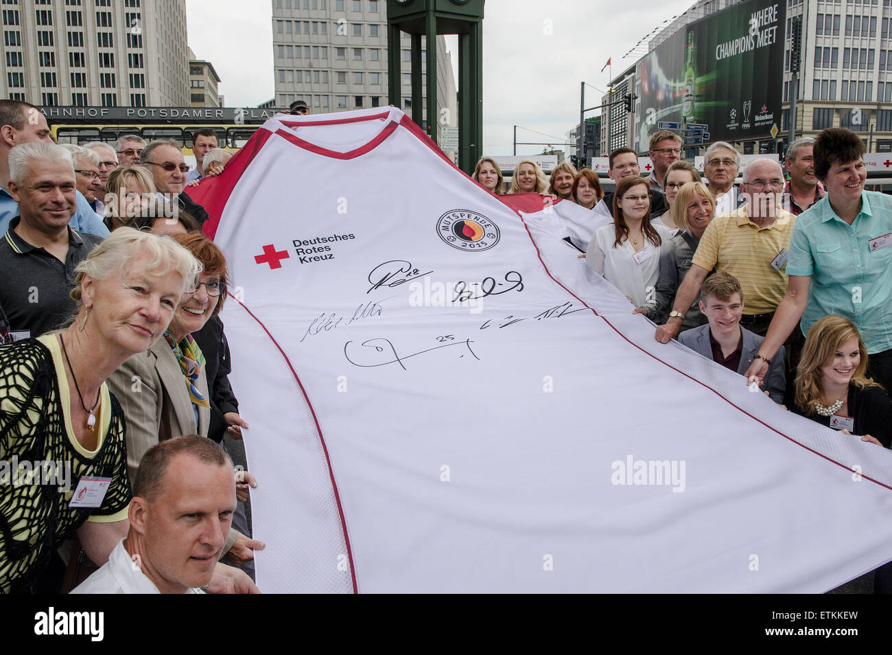 Berlín, Alemania. El 14 de junio de 2015. Los donantes de sangre posar delante de un enorme jersey de la Cruz Roja Alemana durante una campaña de donación de sangre de la organización marcando el Día Mundial del Donante de Sangre en Berlín, Alemania, el 14 de junio de 2015. Foto: Paul ZINKEN/dpa/Alamy Live News Foto de stock