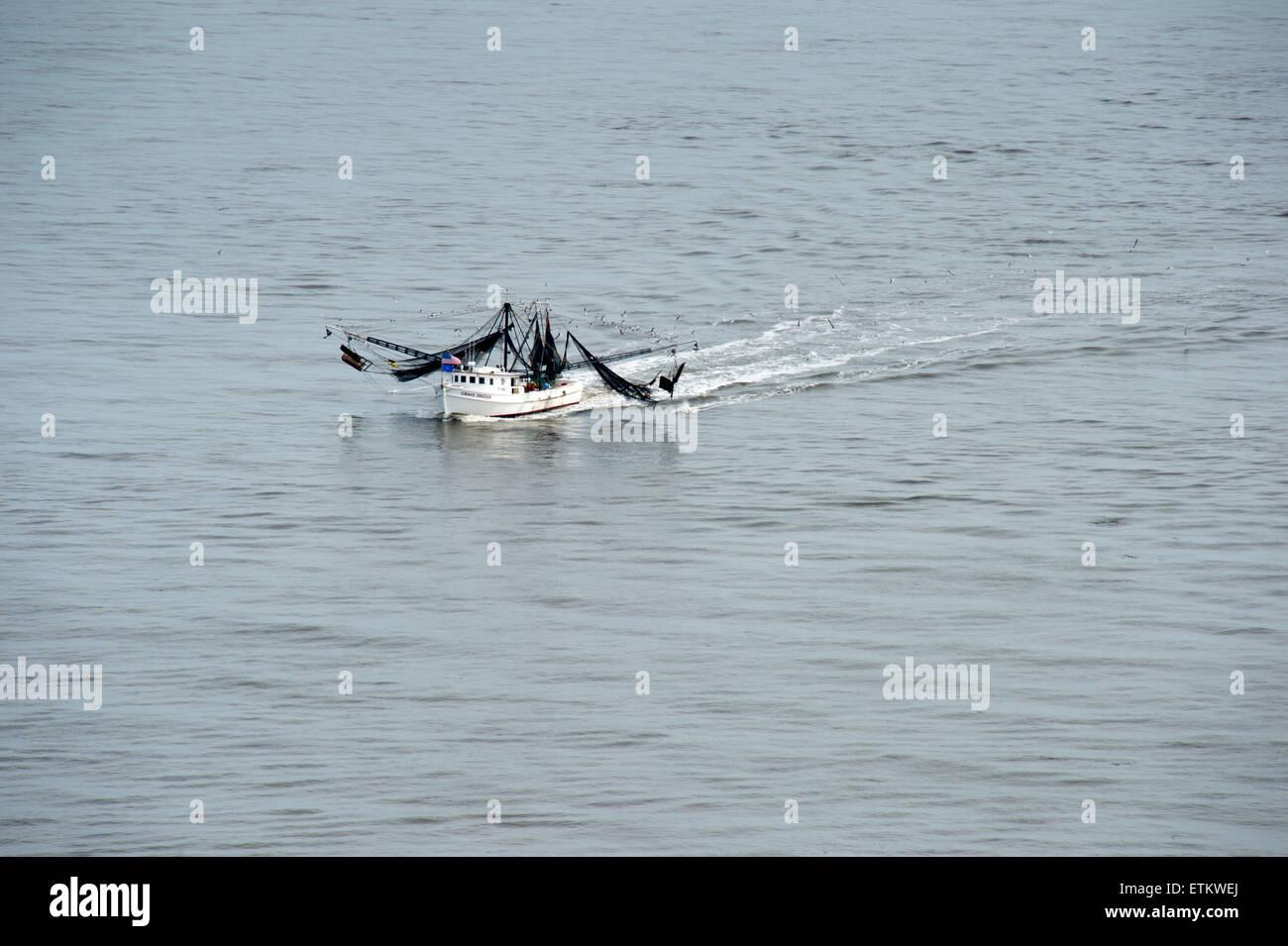 Barco de pesca comercial blanco con negro mosquiteros en el sureste de EE.UU. Foto de stock