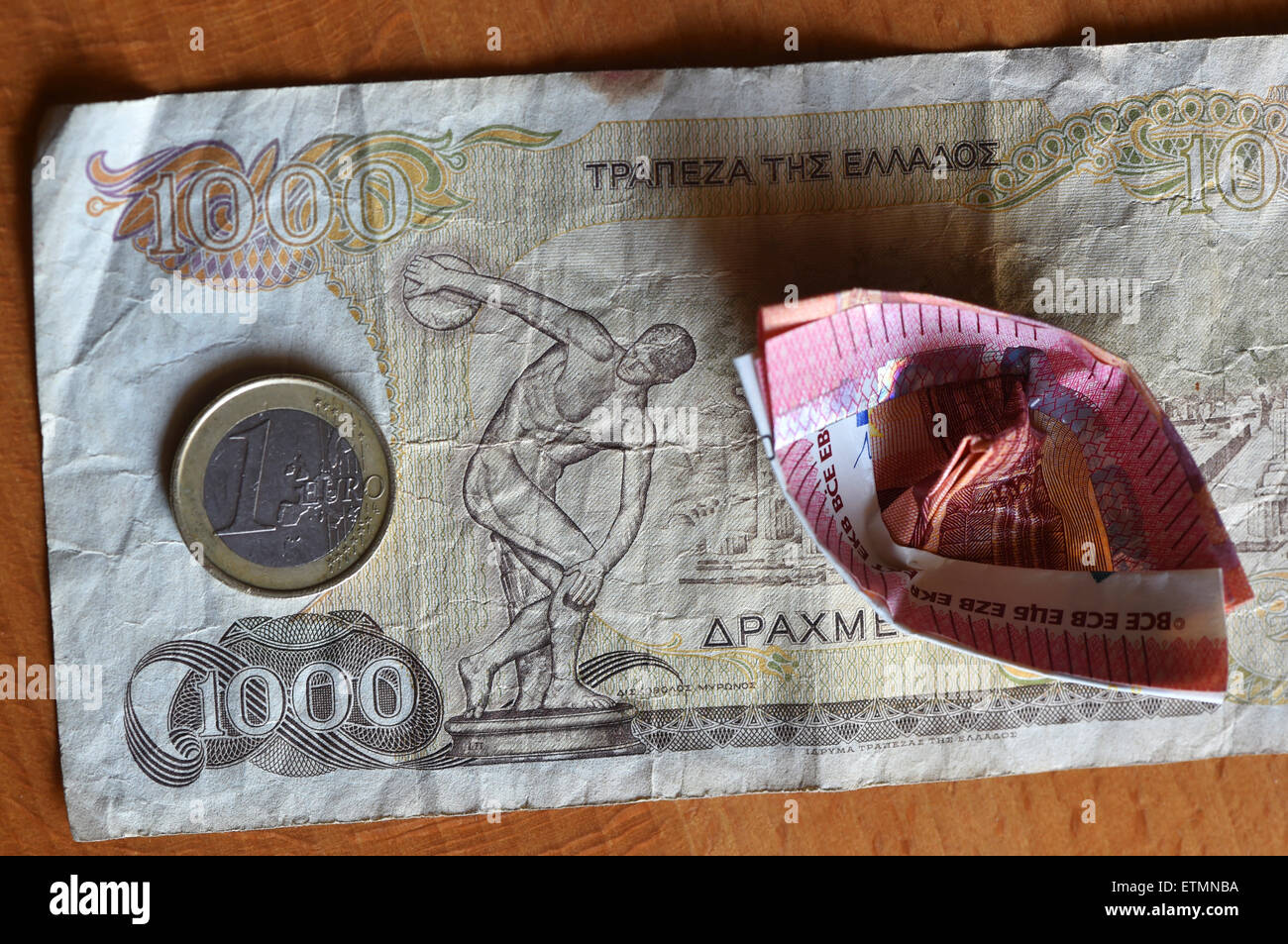 Berlín, Alemania. El 14 de junio de 2015. Ilustración - una moneda en euros y a 10 euros el proyecto de ley que ha sido doblada en un barco yace sobre un dracma griego 1000 Bill en Berlín, Alemania, el 14 de junio de 2015. Foto: Jens Kalaene/dpa/Alamy Live News Foto de stock