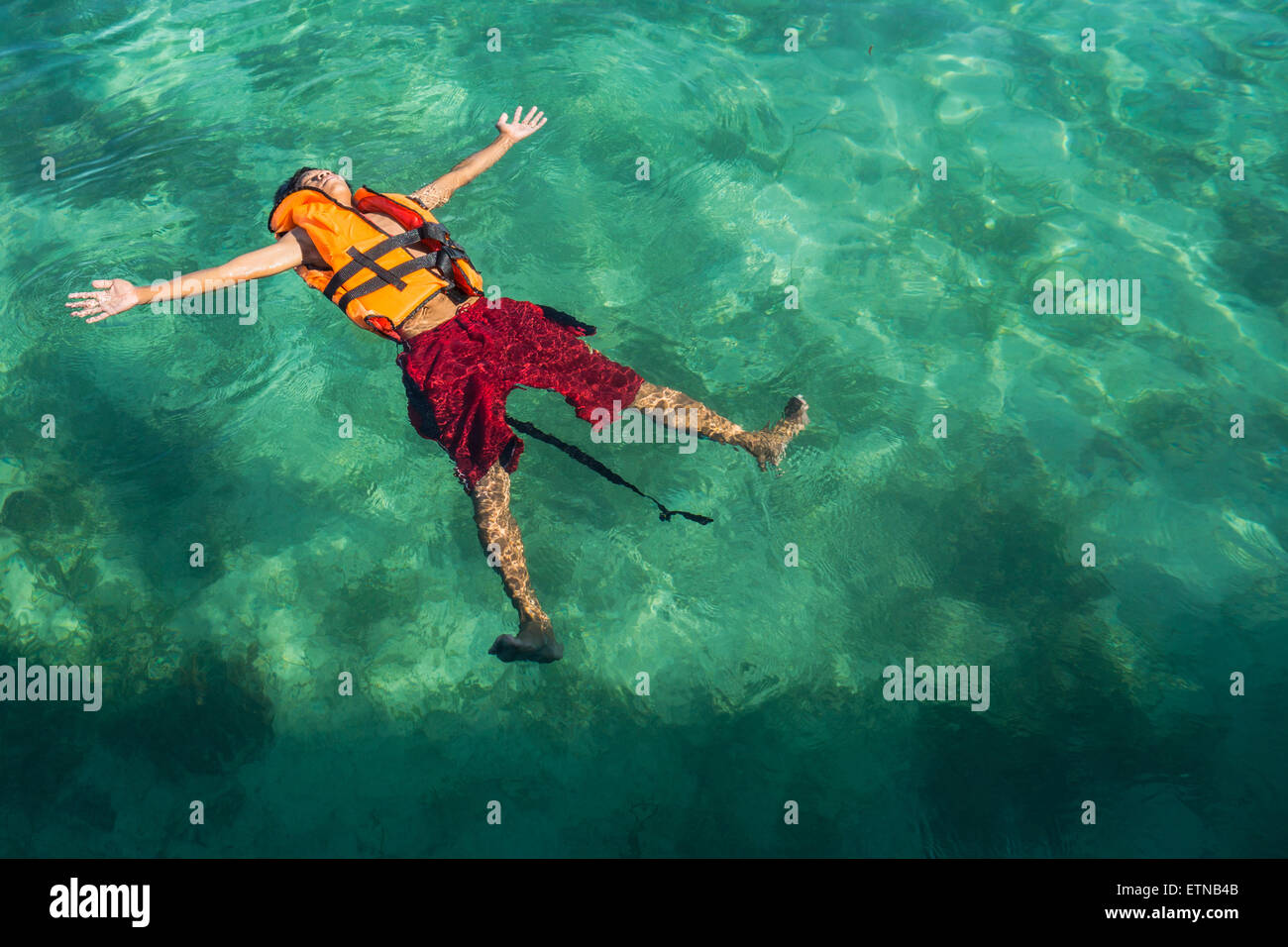 Adolescente vistiendo un chaleco salvavidas, flotando en el mar, la isla de Salakan, Semporna, Sabah, Malasia Foto de stock