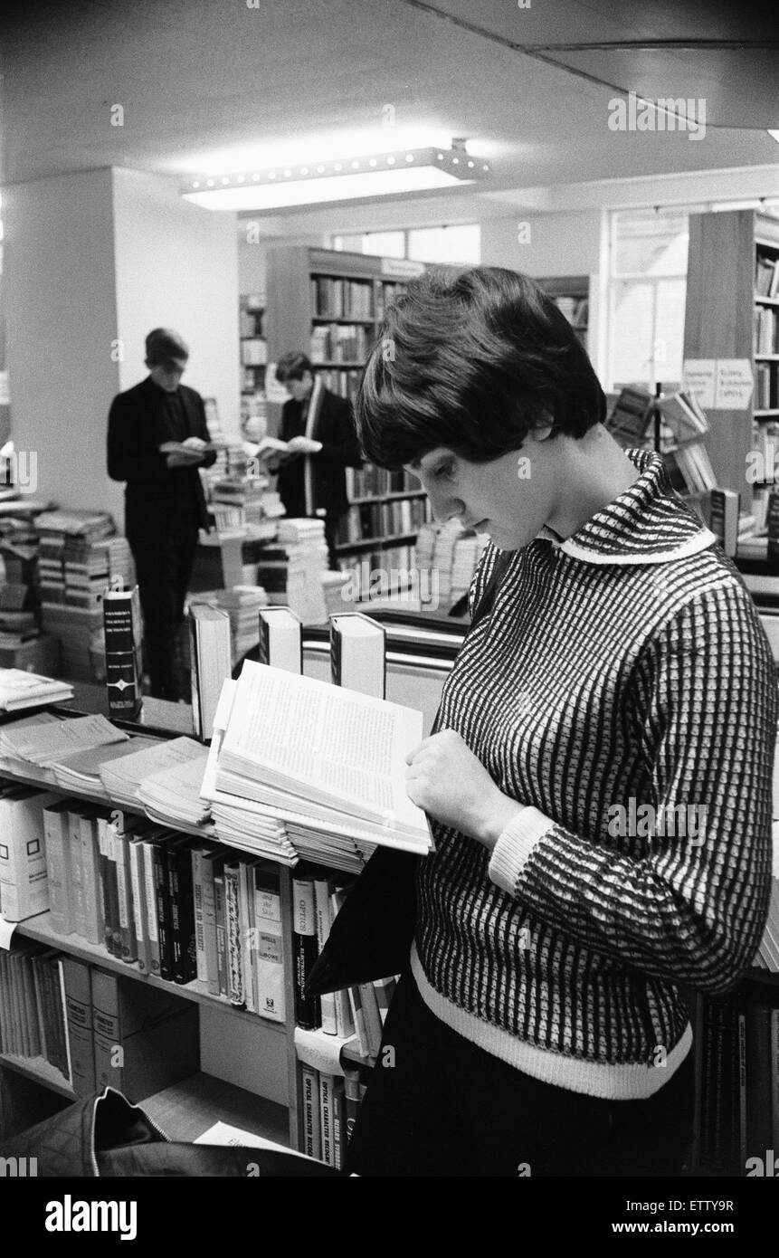 Señorita leyendo un libro de texto en el libro técnico departamento en la librería Foyles en carbonizando Cross Road, Londres. Alrededor de julio de 1966 Foto de stock