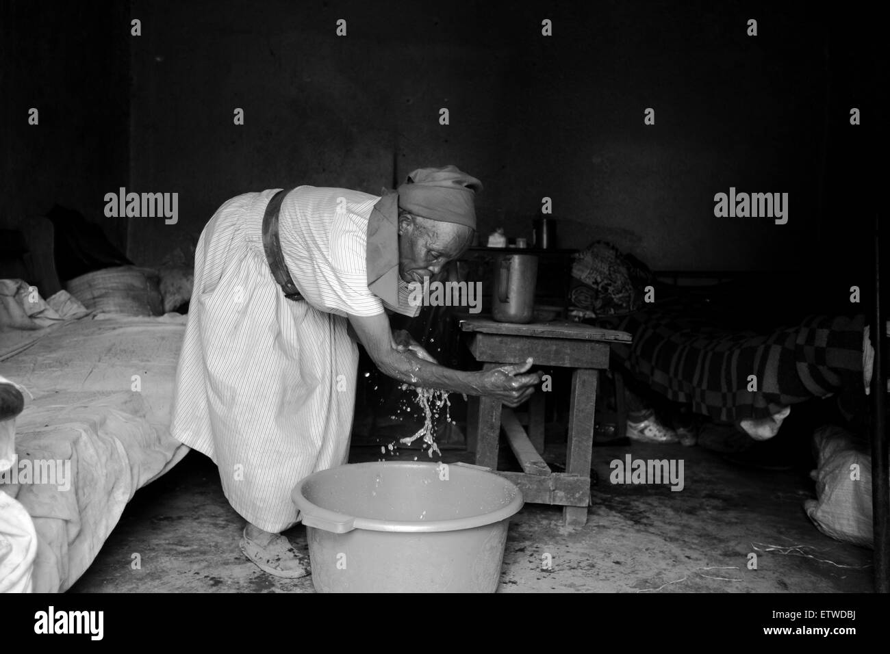 70 años Wairimu Gachenga lavarse como ella llega a su casa desde la Dandora vertedero 28 de mayo de 2013 cerca de la barriada de Korogocho en Nairobi, Kenya. Una vez a la semana, un grupo de abuelas de la zona se reúnen a practicar las técnicas de defensa después de que uno de ellos fueron violadas en 2007. La violación en la mujer de edad avanzada han aumentado en Kenya como la gente cree que las abuelas tienen un menor riesgo de infección por VIH en comparación con las mujeres jóvenes. KAREL PRINSLOO. Foto de stock