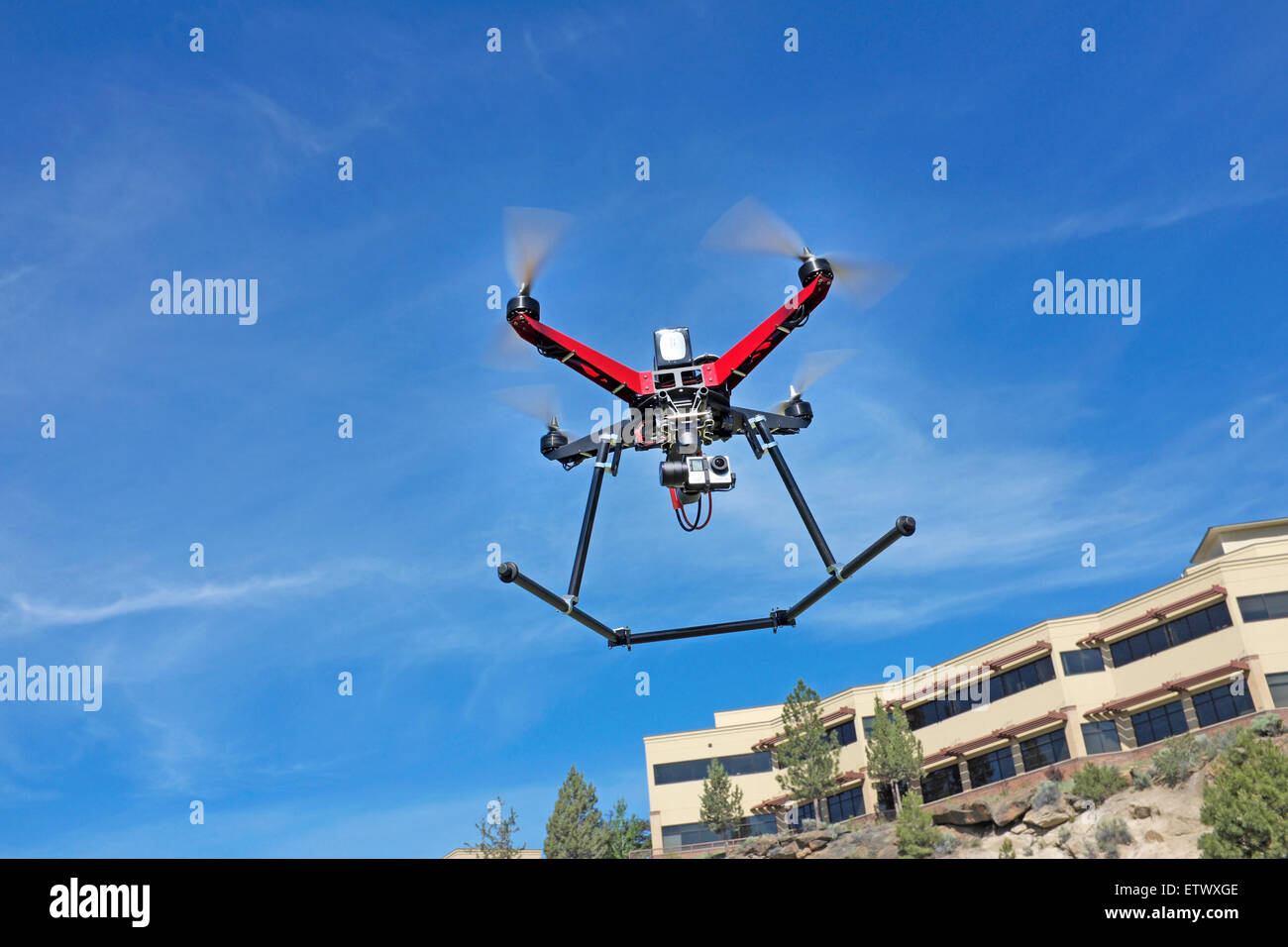 Un quadcopter drone, equipado con una gopro camera, en vuelo. Foto de stock