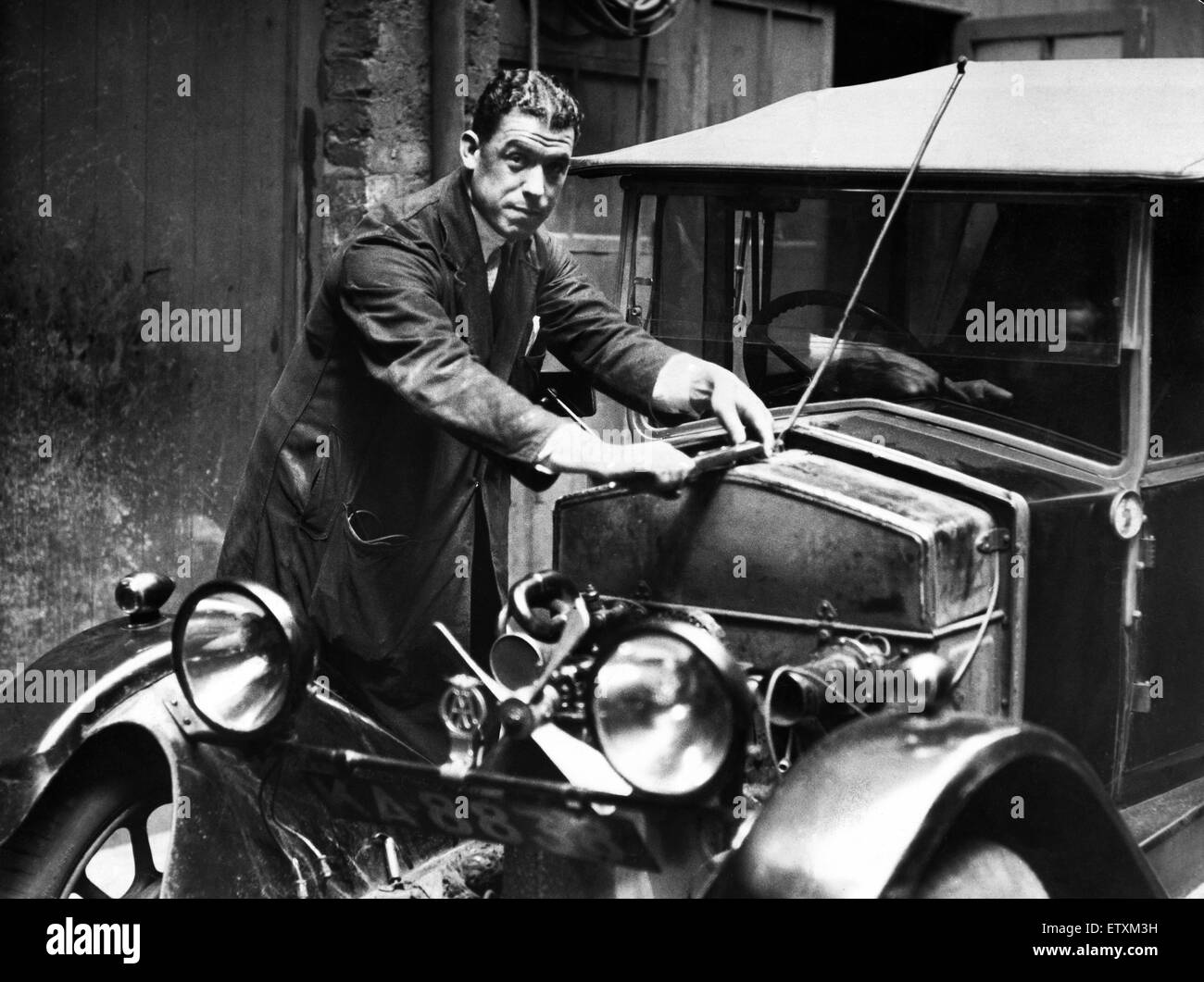 Everton futbolista William 'Dixie' Dean vestido con mono de mecánico como él va a trabajar en un coche. Circa 1936. Foto de stock