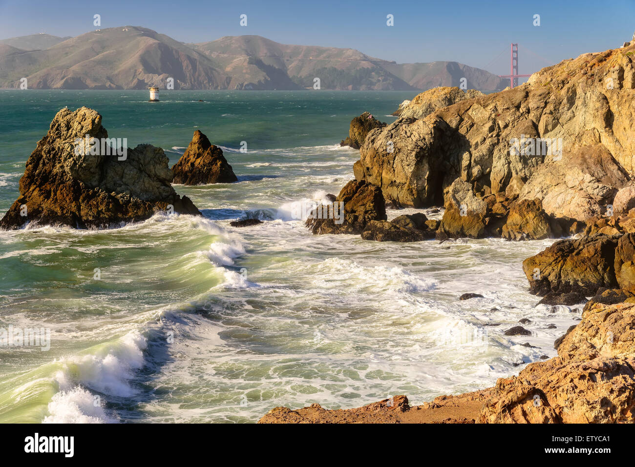 Las olas del mar a pie entre las rocas en la costa de California al atardecer, San Francisco. Foto de stock