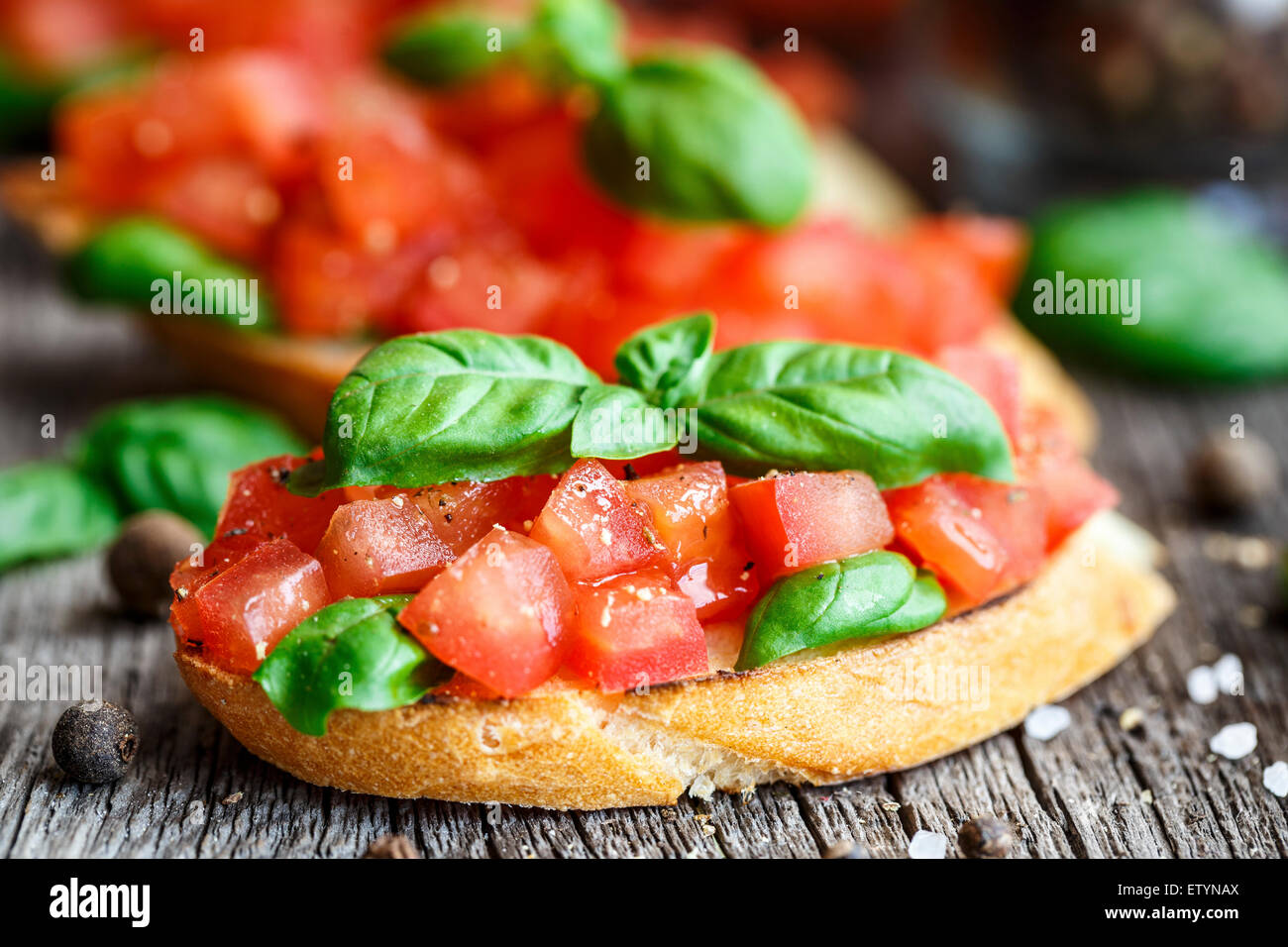 Tomate bruschetta con cubitos de tomate y albahaca en pan tostado Foto de stock
