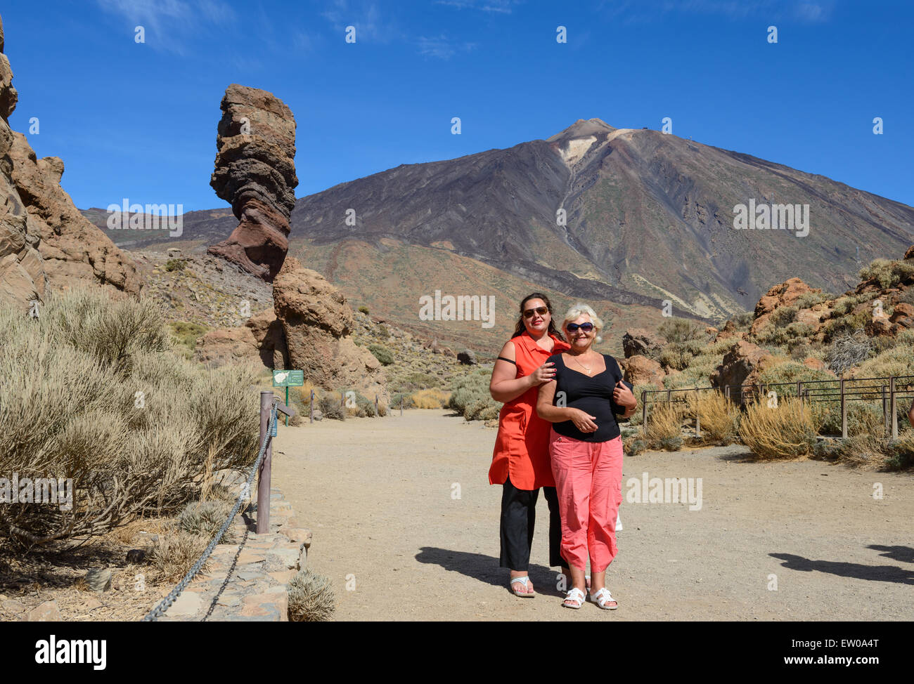 Madre e hija están de pie en el Parque Nacional del Teide antecedentes con la famosa roca Cinchado y Pico de Teide en Tenerife, Foto de stock